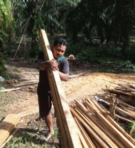 Bantu Nadif Melawan Tumor Paru. Tampak ayah Nadif sedang mengankut kayu.