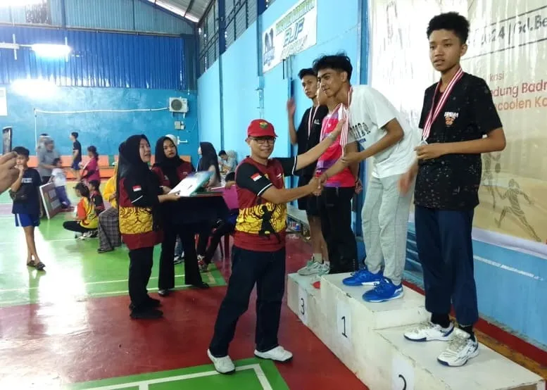 Sekretaris Umum Pengprov PBSI Provinsi Bengkulu Saihoni Anwar, ST, M.Si, mengalungkan medali kepada para juara. foto: tarmandi
