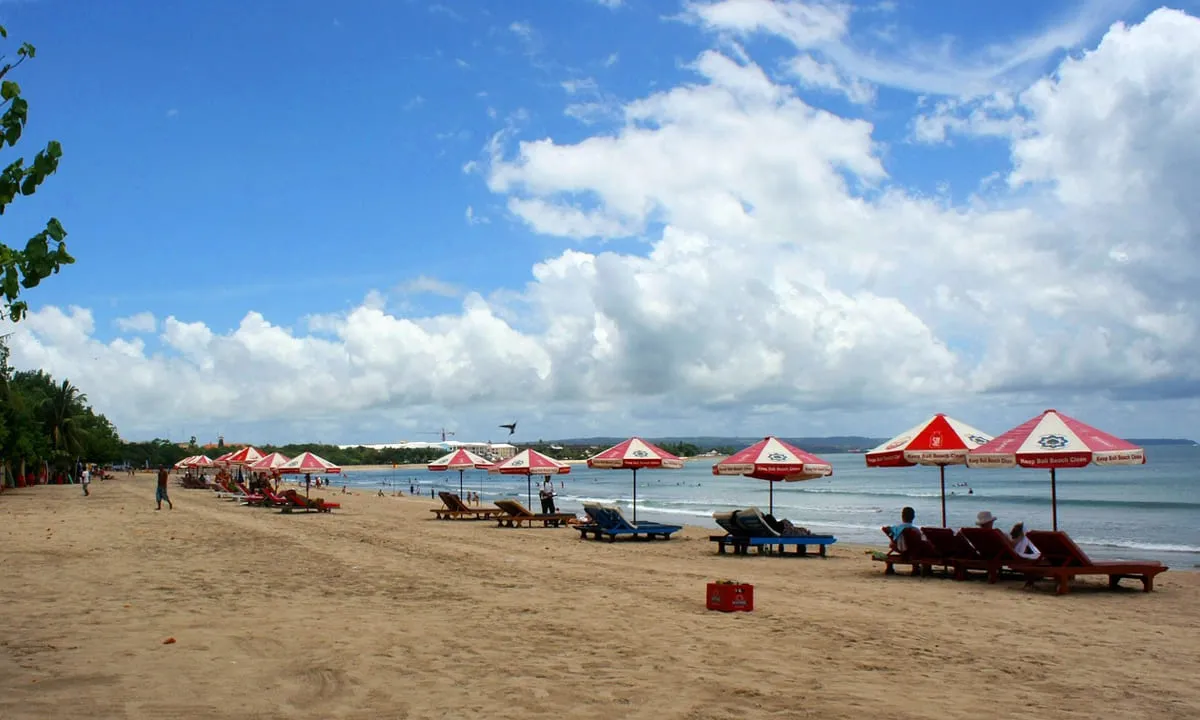 Pantai Kuta dengan ombak yang ideal untuk berselancar di Bali - salah satu tempat wisata Bali terpopuler yang harus dikunjungi