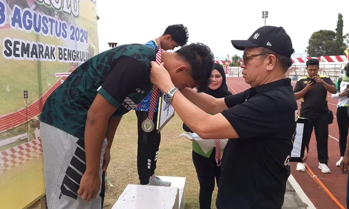 Ketua Pengprov PASI Provinsi Bengkulu mengalungkan medali kepada para juara Kejurda Atletik di Stadion Semarak Bengkulu, Selasa (27/8/24).(foto/tarmandi)