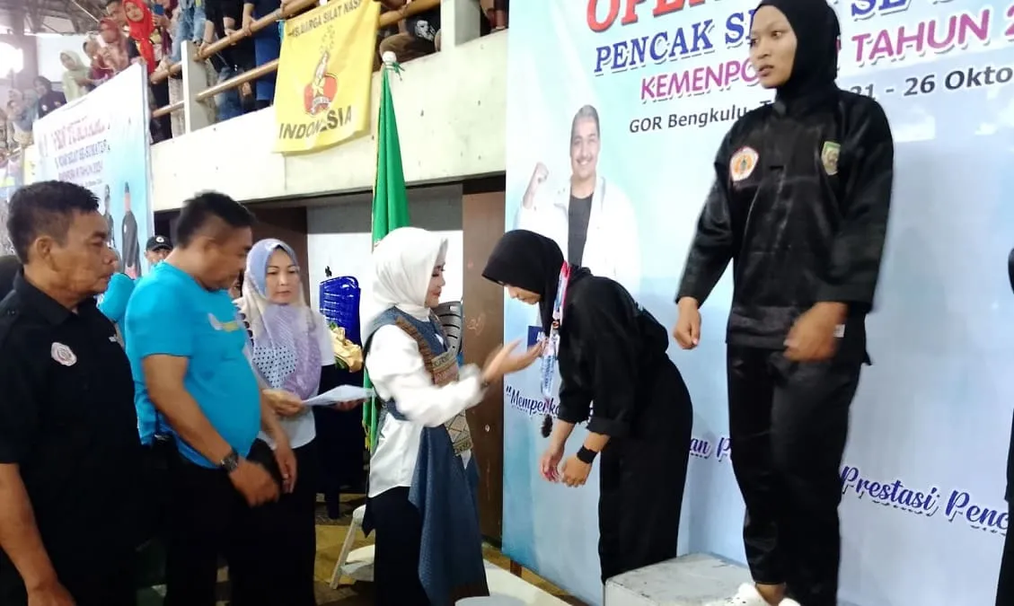 Pembina Pengprov IPSI Provinsi Bengkulu Dr. Hj Dwi Coryati menyerahkan Thropy juara umum kepada kontingen Wahana Mitra.(foto/tarmandi)